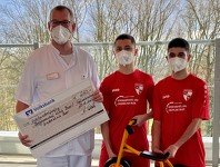 Zwei Jugendspieler des SSV Buer 7/28 e.V. überbringen eine Dreiradspende an den Ärztlichen Direktor der Kinder- und Jugendklinik Gelsenkirchen Dr. Gerrit Lautner.